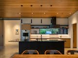 Cedar ceilings throughout are a nod to the cedars in the old-growth forest surrounding the house. A window over the sink gives the homeowners a peek-a-boo view to the front of their house, so they can catch glimpses of foliage, even while washing the dishes.