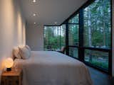 The primary bedroom was kept simple—a bed, nightstands, and a set of chairs—to maximize the forest’s presence. 