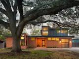 The impactful entry cladding—made from combed Alaskan Yellow Pine—and the custom front door were splurges in the project’s budget. Bhavani calls the back addition a "periscope" because of how it rises above the original home’s footprint.
