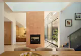 A two-sided fireplace between the living and dining rooms provides separation while maintaining subtle connection. The terra-cotta tiles (from Clay Imports) are a nod to traditional Indian and Portuguese design. The dining room isn't directly near any windows, so Bhavani carved a deep light well above it to bring in natural light. 
