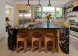 In the kitchen, a striking central island is large enough for the boys to do their homework, while Bhavani and her mother cook dinner. The granite is from AAA Countertops, the stove is BlueStar, and the fridge is Sub-Zero. A flex space (which holds workout gear and Bhavani's office) sits just off the kitchen.