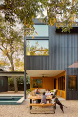 One of the splurges of the project, two walls of combed Alaskan Yellow Pine backing the patio, provide an interesting visual contrast to the dark Hardie siding. West Elm furniture adds a modern touch. 