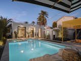 Outdoor, Back Yard, Tile Patio, Porch, Deck, Large Pools, Tubs, Shower, Trees, and Landscape Lighting The giant pivot door leads to a backyard swimming pool and entertainment space.  Photo 18 of 21 in Historic Phoenix Modern Transformation by Elaina Verhoff