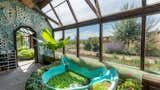 Garage, Sun Room Room Type, Attached Garage Room Type, and Storage Room Type Aquaponic system with 1000-square foot food-producing garden and fish pond  Photo 2 of 14 in Vallecitos Earthship by Jessica Johnson