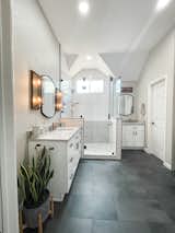 Slate black tile bathroom floor , white contemporary shower with quartz waterfall ledge. White vanities. Champagne bronze plumbing fixtures   Photo 1 of 15 in Cloverleaf Bathroom by Selena Rosete