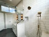 White subway tile with quartz waterfall ledge  Photo 2 of 15 in Cloverleaf Bathroom by Selena Rosete