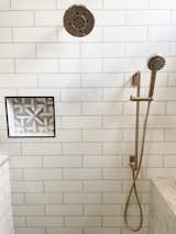 Champagne bronze faucet with geometric built in shower niche. 
