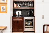 Kitchen, Wood Cabinet, Concrete Counter, Accent Lighting, Ceiling Lighting, Recessed Lighting, Beverage Center, Ceramic Tile Backsplashe, and Undermount Sink Everyone needs a bar. Pic frames on the left are made from old baseboards.   Photo 13 of 18 in Old to Almost New by Pamela Bowles