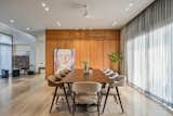 The bold blue and red strokes on the customized Dali art-piece stands on the veneer paneled surface concealing a door to the powder toilet behind it, in the dining space with the hues of greys and browns.