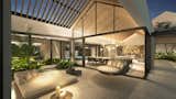 A neutral color palette, dominated by soft beiges, whites, and greys, is contrasted by rich wood tones in the ceiling panels and furnishings, while the generous roof volumes balance light and heat from the Florida sun with a sense of space and air.