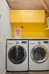 The washer and dryer were moved from the kitchen to the back of the guesthouse. We went with energy efficient electric LG units. We used 1950's diner-style formica for the workbench, and painted the custom shelving and cabinetry a cheerful yellow.