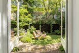 Outdoor, Back Yard, Garden, Grass, Stone Patio, Porch, Deck, Trees, Landscape Lighting, Shrubs, Wood Fences, Wall, and Wood Patio, Porch, Deck A peak at the garden   Photo 8 of 10 in The Reguliersgracht House by Marina Corona
