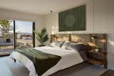 The deck also connects beyond to a semi-private deck off the primary bedroom suite. Picking up the natural material palette again the bedroom is furnished with walnut accents and small potted plants, which then translates through to the bathroom. 