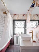 Cheeky wallpaper and pink and gold accents make for a playfully refined bathroom.