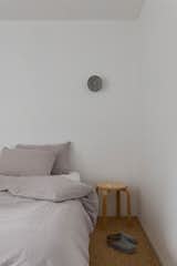 Sisal carpet in the two bedrooms adds natural texture. The Anton aluminum wall light is from Volker Haug Studio and the bed is a floating blackbutt timber frame from Create Estate.