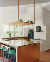 The tiled wall cleverly hides a Juliet balcony above the kitchen, a space for the owners' teenage daughter to do homework, draw and interact with the family from afar.