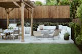 Backyard outdoor kitchen, dining, and firepit area with custom l-shaped bench 