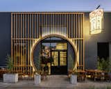 Modified circular storefront facade inspired by Moon gate architectural passageways in China serves as an inviting portal between exterior and interior. 