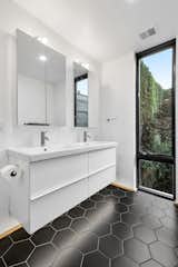 Primary bath using simple IKEA fixtures, overstock tile and floor to ceiling windows.