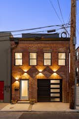 The front of the home at twilight - the historic brick facade and shell was preserved and a new home was inserted within it. 