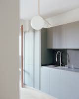 Kitchen, Pendant Lighting, Colorful Cabinet, Undermount Sink, Medium Hardwood Floor, and Stone Counter Kitchen  Photo 6 of 14 in Apartment with a Dining Room by Olbos Studio