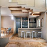 Kitchen, Dishwasher, Ceiling Lighting, Wood Cabinet, Range, Wood Counter, Range Hood, Microwave, Wall Oven, Cooktops, Ice Maker, Medium Hardwood Floor, Refrigerator, Metal Backsplashe, and Drop In Sink Designed by Tan Yamanocuhi & AWGL  Photo 12 of 20 in A Cat Tree House by Tan Yamanouchi & AWGL