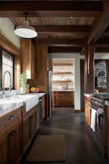 Kitchen, Marble Counter, Range, Pendant Lighting, Wood Cabinet, Dishwasher, Concrete Floor, Ceiling Lighting, Refrigerator, Marble Backsplashe, and Drop In Sink Kitchen  Photo 14 of 27 in Glacier's Edge by Timberbuilt