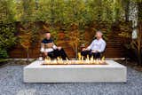 The clients Andrew and Anthony unwind before an outdoor dinner party at the warmth of the their concrete firepit