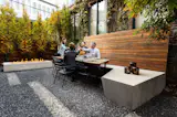Guests sit at the custom designed concrete and wood bench and screen.