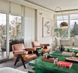 The beige colour palette is combined with bold-coloured armchairs and coffee tables.