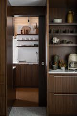 The pocket door is seamlessly hidden in the cabinetry, sliding behind the coffee bar. Concealing messy projects or laundry from company.