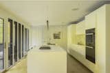 Bathed in natural light, the kitchen’s all-white design is elevated through subtle material contrasts.
