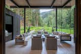The long shed roof lifts toward the sound of the creek, sheltering a generous covered deck that invites year-round connection to nature.