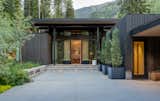 Deep roof overhangs and recessed apertures offer protection from the elements while creating rhythmic shadows across the exterior facade.