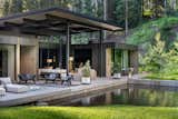 The architecture is broken into two distinct volumes—guest and primary wings—connected by a covered outdoor deck that amplifies the indoor-outdoor experience.