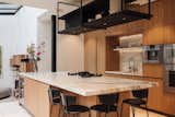 Kitchen, Marble Counter, Dishwasher, Refrigerator, Wine Cooler, Cooktops, Wall Oven, Microwave, Marble Backsplashe, Ceiling Lighting, Wood Cabinet, Range, Undermount Sink, Beverage Center, and Recessed Lighting Kitchen  Photo 7 of 30 in Historic Canal Home in Amsterdam by Amy Deutcher