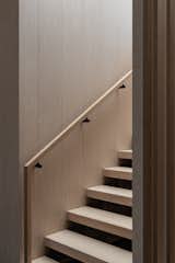 The balustrade and stair treads cantilever off a timber panelled wall that extends over both levels
