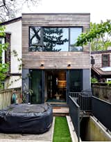 The rear of the addition includes the living area with sliding glazed doors, a stair to the basement, and a small wood deck to the back yard.