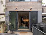 The north-facing rear facade includes thermally modified ash cladding, fiberglass reinforced concrete panels, sliding glazed doors, and a wood deck.  Photo 6 of 16 in Addition and Renovation in Cabbagetown by Leo Mieles