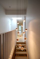 A suspended light fixture, a steel guard and a skylight feature at the top of the main stair.