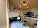 A standard WorkPod interior has a bookshelf and an electrical cabinet; a furnished model ships with a smart desk, ergonomic chair, filing cabinet, anti-fatigue mat, and cable tray.