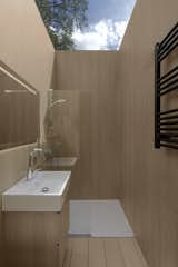 The wood-clad shower has a see-through roof.