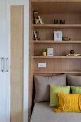 The guestroom abstracts a bright summer day spent outside in nature. The soft furnishings in shades of ochre, seafoam green and abalone grey balances harmoniously with the tan brown of the wooden storage. The color palette is tranquil yet exuberant.
The horizontal lines of shelves contrast well with the verticality of the storage cupboards, highlighted in eggshell white beautifully completing the look to a welcoming space.
