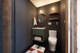 The unit features two side by side restrooms that were once designated for the cafe. We used Zia Tile in Ironwood to bring the paneling color into the back of the unit, and popped some color off it with Dutton Brown sconces. Quiet Town rug.