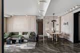 The muted modern sleek living room with grey marble flooring and a curved emerald sofa as the highlight and simple black and white arm chair by its side, walls with Victorian panelling finished is texture and black wooden cornice running on all border add character to the space . On the left is simple elegant mandir with triangle fluting and on the right is an oblong Michael Angelo Dining table with bronze metal legs and black domed shaped pendant light.Globe lights on ceiling add to the drama and grandness of room.
Sofa ,Dinning Table , Dinning Chair - Custom Made
Carpet - Jaipur Rug
Center table- Eter 
Dinning Light - Shailesh Rajput
Arm Chair - The Pure Concept Home
