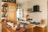 Kitchen, Marble Backsplashe, Wood Cabinet, Quartzite Counter, Dishwasher, Range, Wood Counter, Drop In Sink, Refrigerator, Ceiling Lighting, Cement Tile Floor, Microwave, Metal Backsplashe, Cooktops, and Wall Oven  Photo 3 of 13 in The Collected Home by Meghna