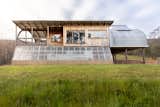 Exterior, Concrete Siding Material, Glass Siding Material, Metal Roof Material, Farmhouse Building Type, Wood Siding Material, and Curved RoofLine The greenhouse acts as a passive heater as warm air rises up into the living space above  Photo 9 of 22 in Valleys Hearth by Marcus Englmayr