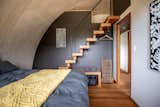 Bedroom, Bed, Ceiling Lighting, Shelves, Medium Hardwood Floor, and Storage More recycled timber, stairs that lead to little loft spaces to maximise the use of the spacious curved ceilings  Photo 12 of 22 in Valleys Hearth by Marcus Englmayr