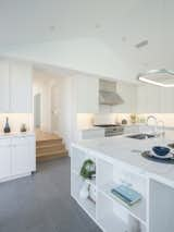 Kitchen, Engineered Quartz Counter, Range, Ceiling Lighting, Ceramic Tile Floor, Cooktops, Undermount Sink, Pendant Lighting, White Cabinet, Wood Cabinet, Subway Tile Backsplashe, Wall Lighting, Range Hood, and Recessed Lighting Kitchen  Photo 11 of 17 in 99 Ranch by Yu2e