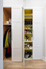 Additional storage behind range wall.  Coat closet and pantry with a yellow interior